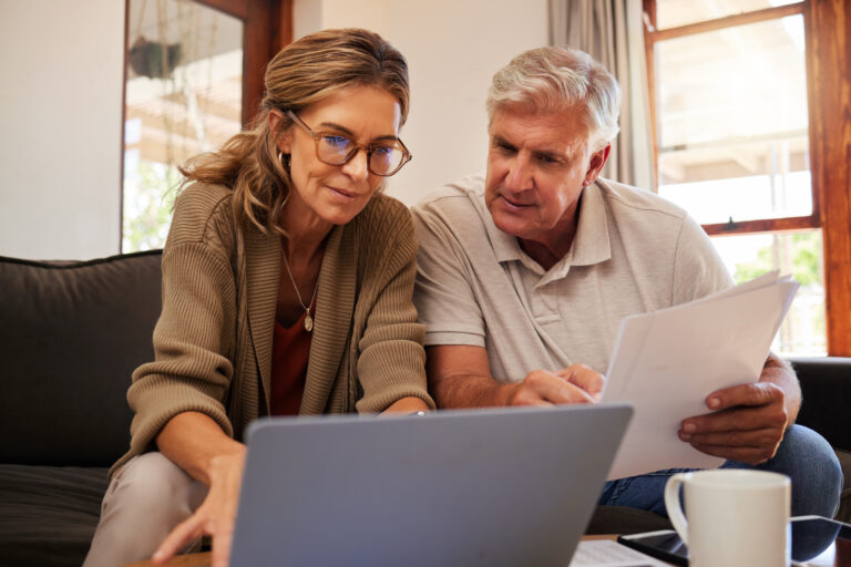 Retirement couple budget, finance and investment planning, loan and paper bills with laptop technology in home. Mature people money, cash savings or legal insurance document report on online bank