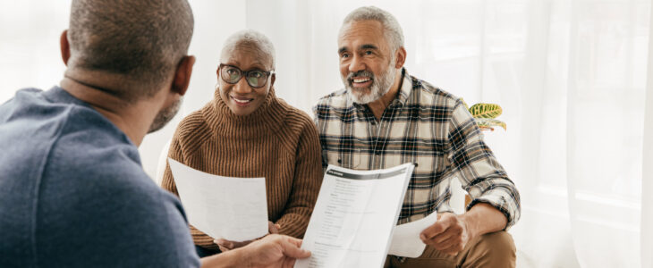 Older couple talking to health insurance broker