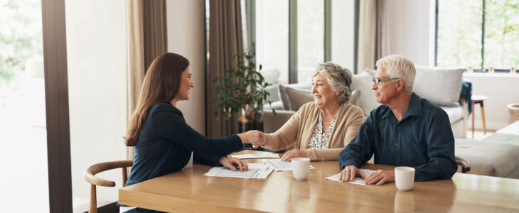 Estate planning attorney shaking hands with older couple