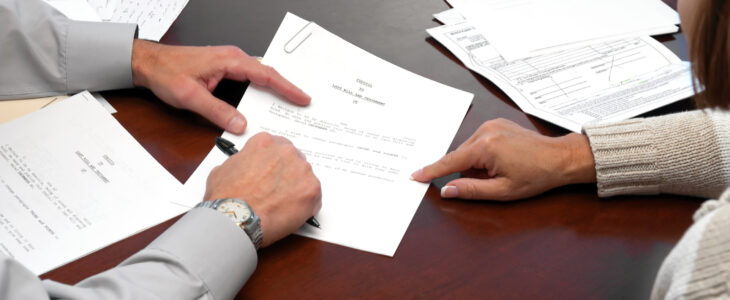 An estate planning attorney and a client signing a trust