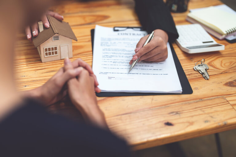Female lawyer asking a client to read the contract before signing to agree to estate plan.